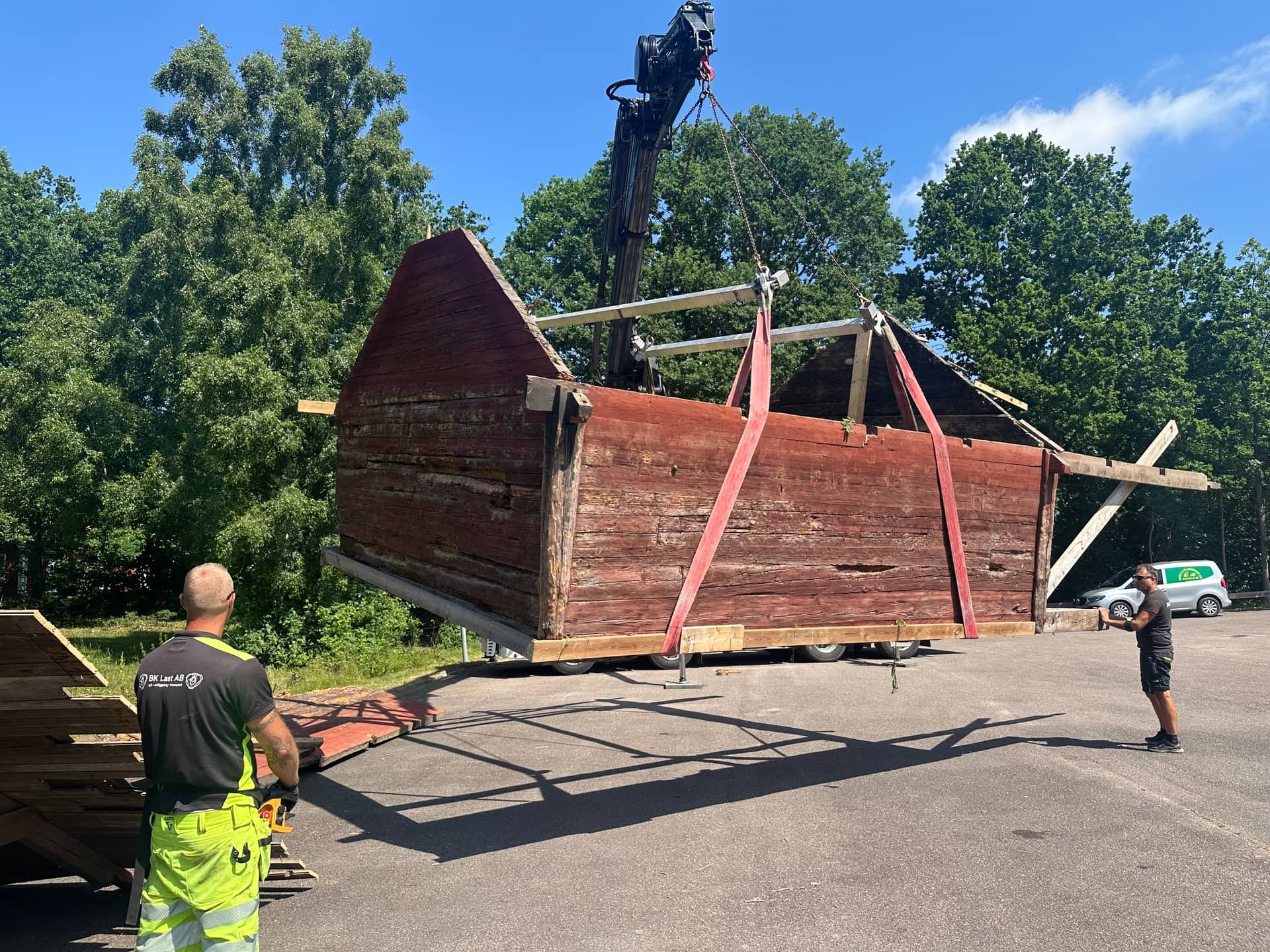 Kran lyfter röd linbasta med lyftok och stroppar