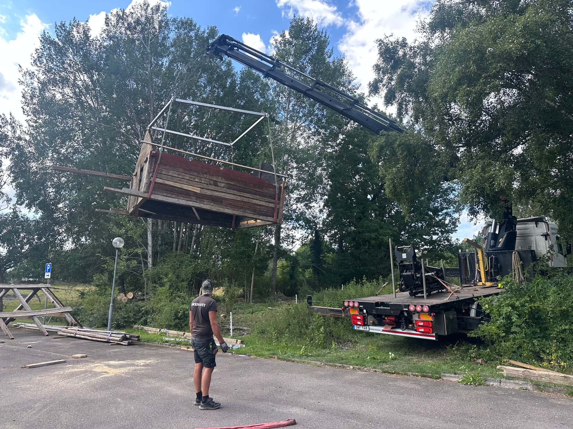 Linbasta i luften vid kranlyft, arbetare följer arbetet