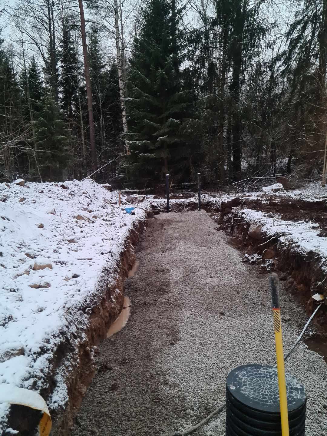 Schakt med makadambädd och brunn i snöigt skogsbryn